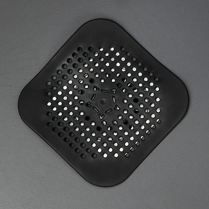 Black square silicone drain hair catcher on a gray background