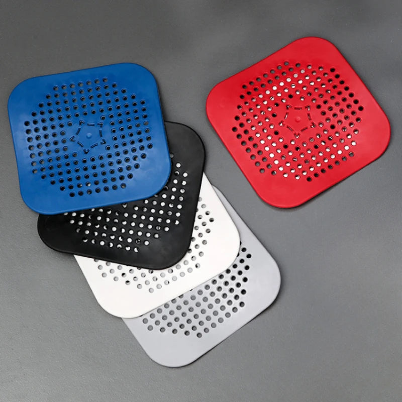 Five square silicone drain hair catchers in blue, black, white, and red