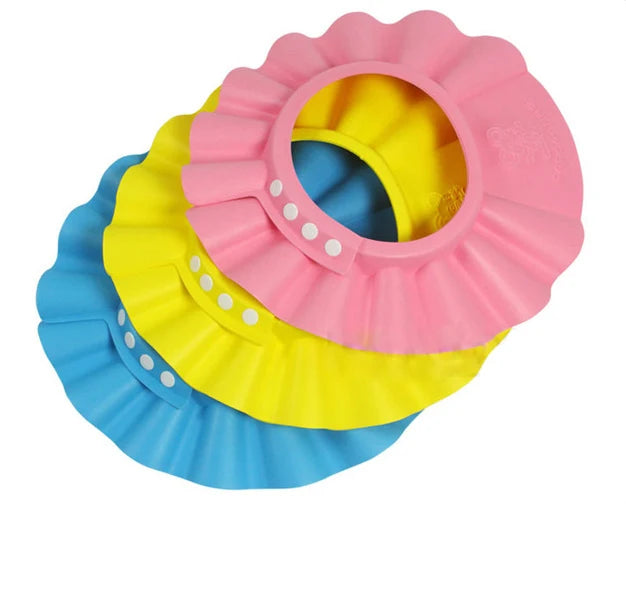 Three colorful shower caps in pink, yellow, and blue on a white background