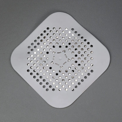 Square plastic drain cover with holes on a gray background