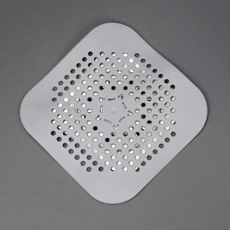 Square plastic drain cover with holes on a gray background