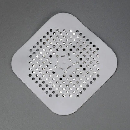Square plastic drain cover with holes on a gray background