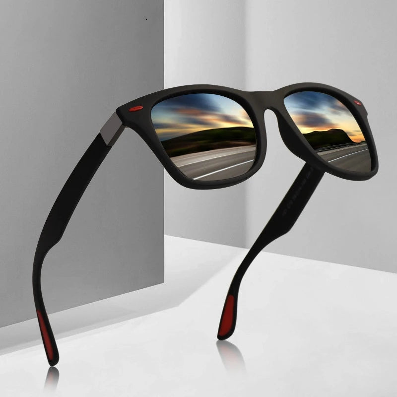 Black sunglasses with reflective lenses showing a scenic road, on a gray background