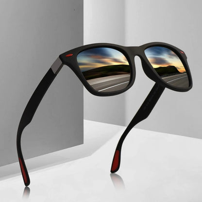 Black sunglasses with reflective lenses showing a scenic road, on a gray background